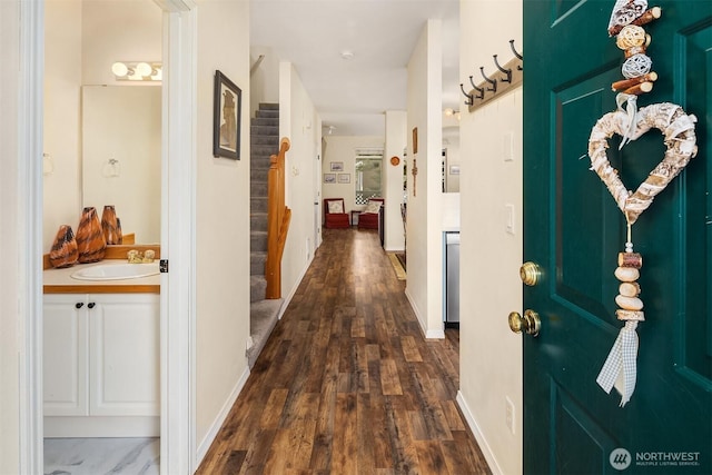 interior space featuring stairs, dark wood-type flooring, and baseboards