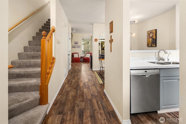 interior space featuring stairway, baseboards, dark wood finished floors, and a sink