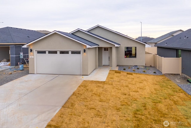 single story home featuring a garage, concrete driveway, fence, and stucco siding