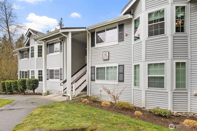 view of front of house with a front yard, driveway, and stairs