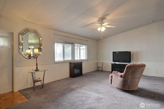 sitting room featuring vaulted ceiling, wainscoting, and a ceiling fan