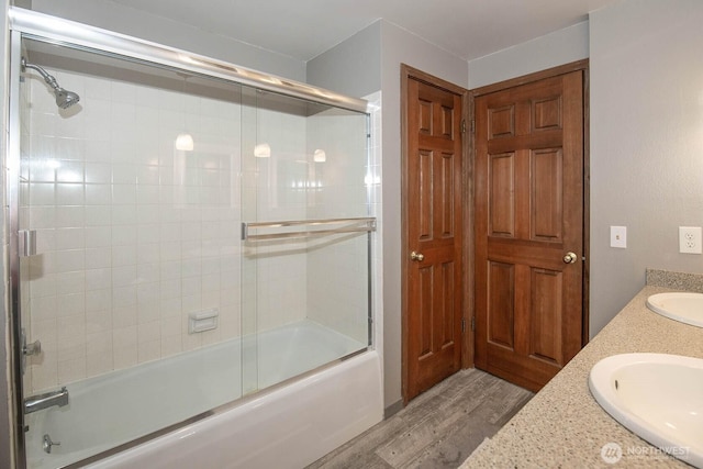 bathroom featuring enclosed tub / shower combo, wood finished floors, and vanity