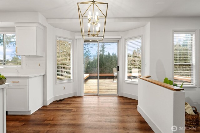 doorway to outside with baseboards, visible vents, and dark wood finished floors