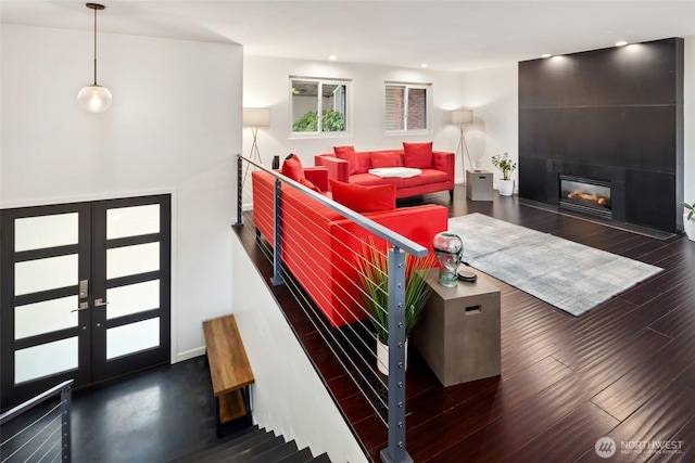 living area with recessed lighting, french doors, a large fireplace, and dark wood-style flooring