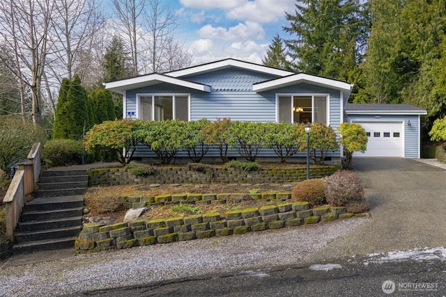 view of front of house with a garage, stairs, and aphalt driveway