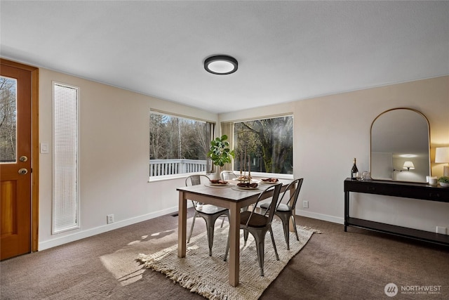 carpeted dining space featuring baseboards