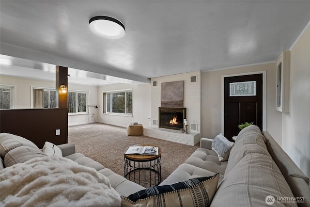 living room featuring carpet floors, visible vents, a fireplace, and baseboards