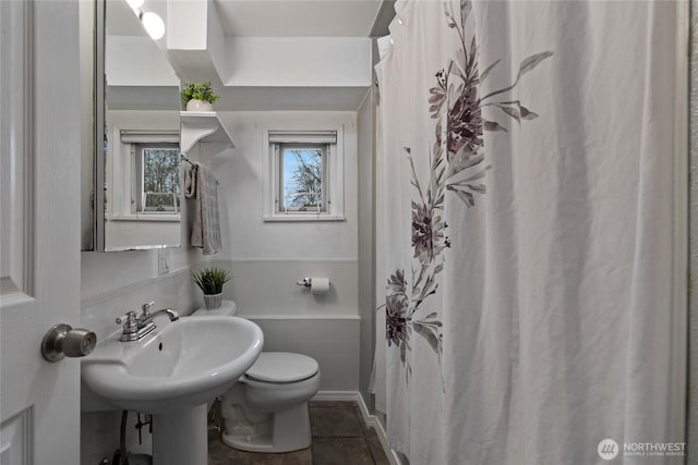 bathroom with a sink, toilet, and tile patterned floors