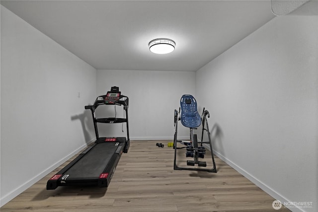 workout room featuring light wood-type flooring and baseboards