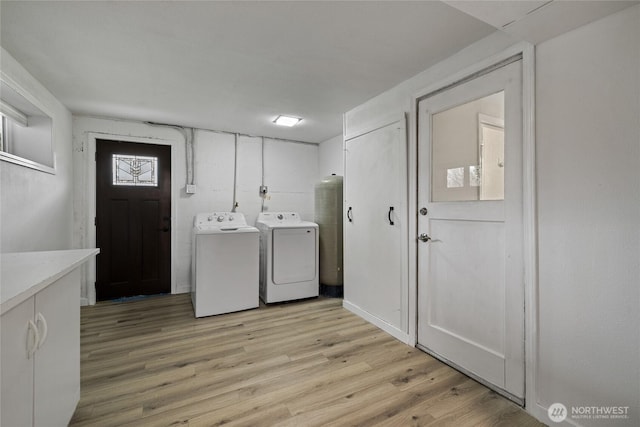 clothes washing area featuring light wood-type flooring and washing machine and clothes dryer