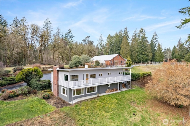 back of property featuring a deck and a lawn