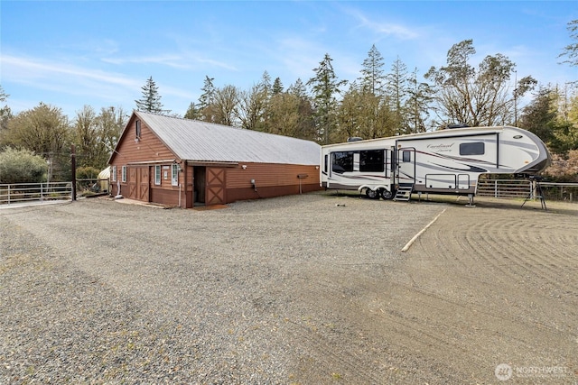 view of front of property with metal roof and fence