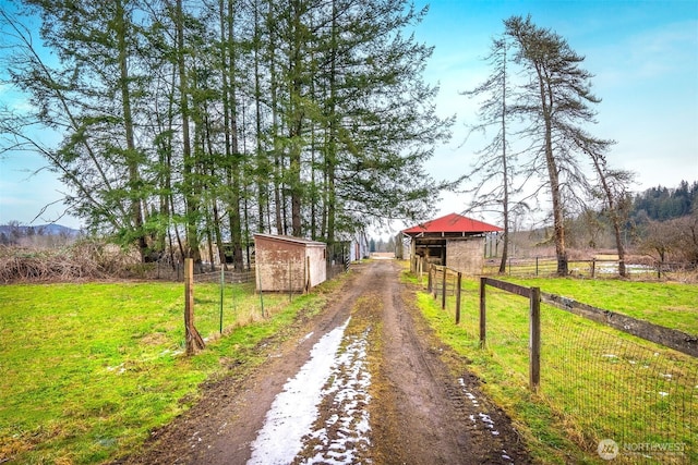 view of road featuring an exterior structure and a rural view