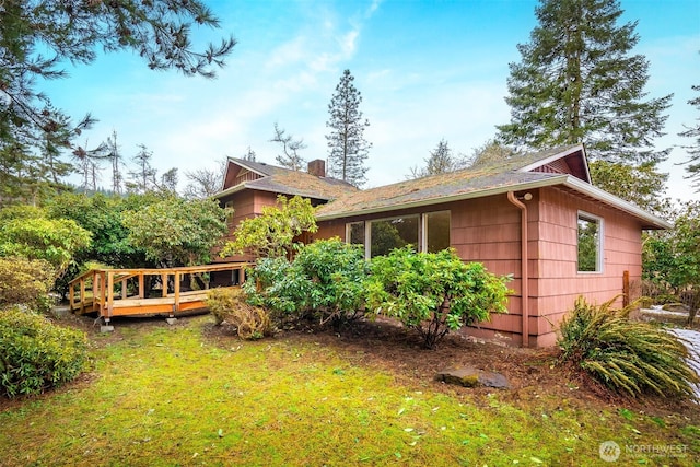 view of side of home featuring a lawn and a wooden deck