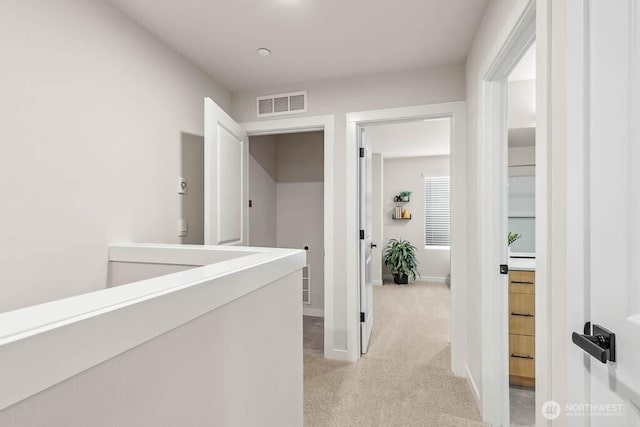 hallway featuring light colored carpet