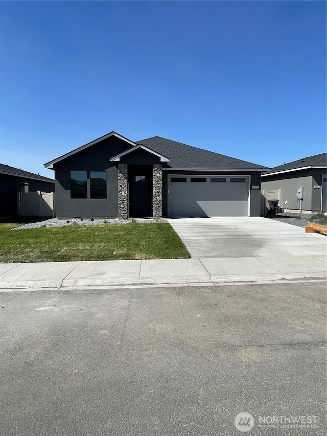 1011 9th Ave NE, Ephrata, WA 98823 - view of front of property with an attached garage, concrete driveway, stone siding, and a front yard