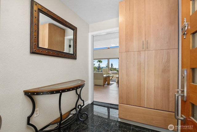 hallway with granite finish floor and baseboards