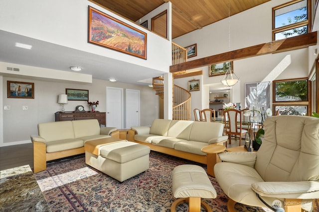 living area featuring visible vents, a high ceiling, wood finished floors, wooden ceiling, and stairs