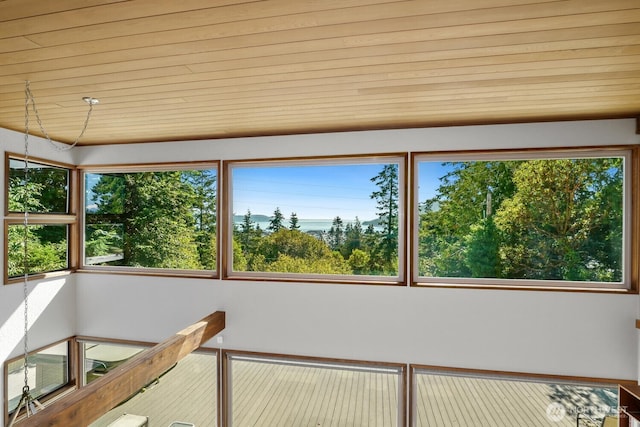 unfurnished sunroom featuring plenty of natural light and wooden ceiling