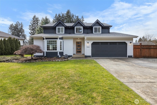 view of front of home with board and batten siding, a front yard, concrete driveway, and fence