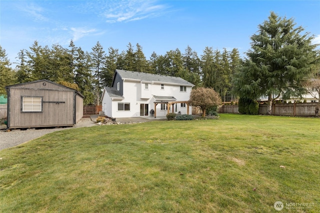 back of property featuring a storage shed, a yard, an outdoor structure, and a fenced backyard