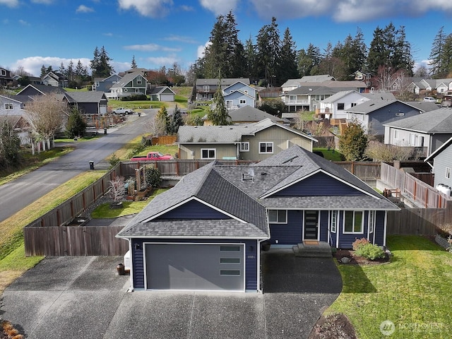 view of front facade featuring entry steps, a shingled roof, a residential view, fence, and a front yard