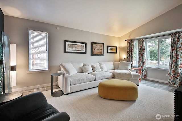 living room featuring baseboards, vaulted ceiling, and wood finished floors