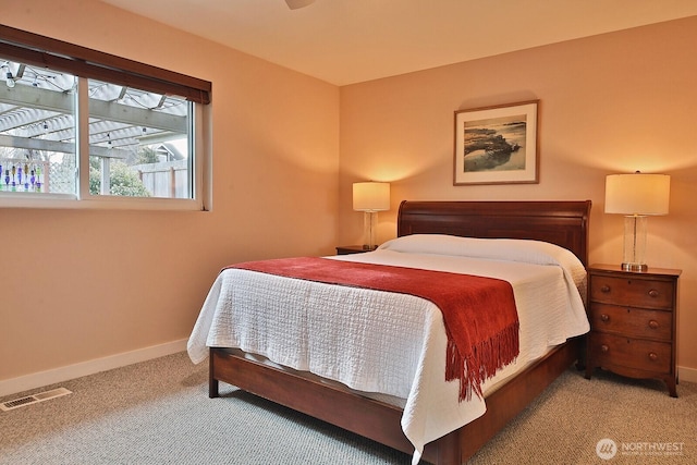 bedroom with light colored carpet, visible vents, and baseboards