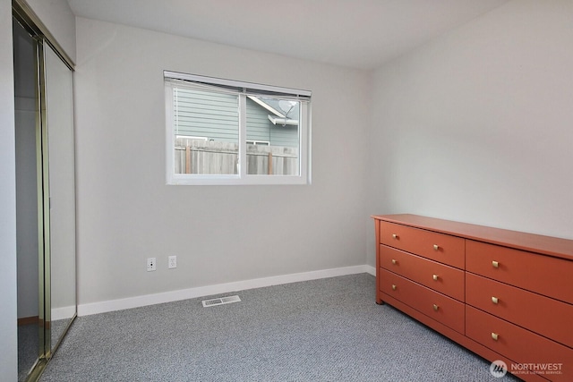 unfurnished bedroom featuring a closet, light colored carpet, visible vents, and baseboards