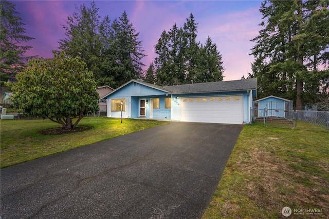 single story home featuring a garage, driveway, fence, and a front lawn