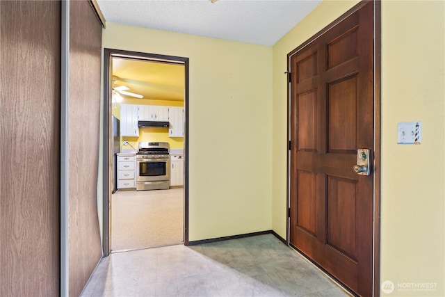 interior space with ceiling fan and baseboards