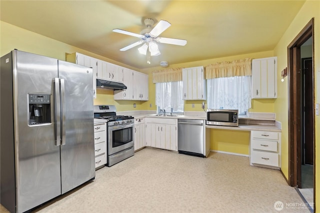 kitchen with light countertops, appliances with stainless steel finishes, white cabinetry, ceiling fan, and under cabinet range hood