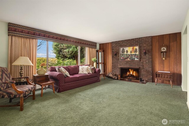 carpeted living room featuring a brick fireplace and wooden walls