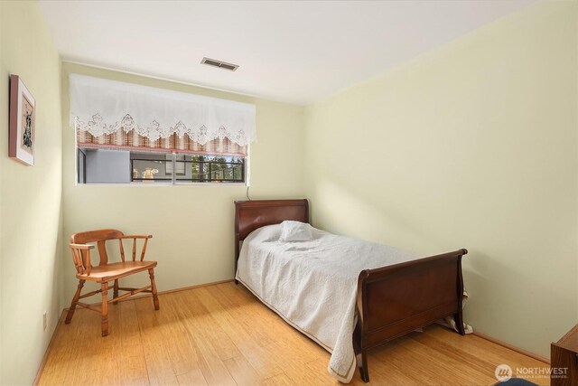 bedroom with visible vents and wood finished floors