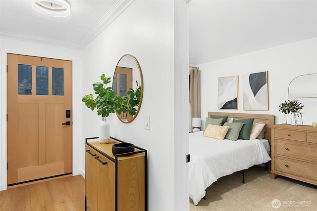 bedroom featuring ornamental molding and light hardwood / wood-style flooring