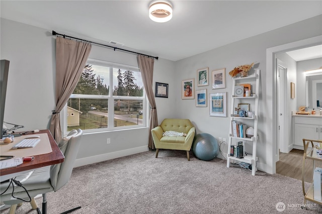 office with baseboards and light colored carpet