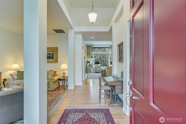 entrance foyer featuring light wood-style flooring, visible vents, and baseboards