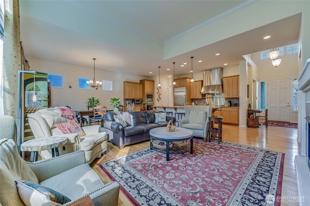 living area featuring a chandelier, crown molding, recessed lighting, and light wood-style floors