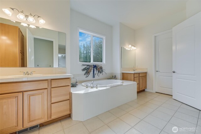 bathroom featuring a garden tub, two vanities, visible vents, a sink, and tile patterned flooring