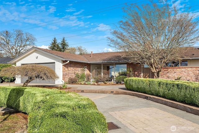 ranch-style house with a garage and brick siding