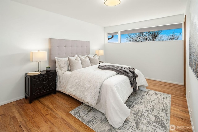 bedroom with baseboards and wood finished floors