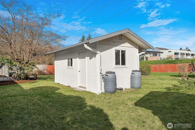 exterior space featuring a lawn, an outdoor structure, and fence