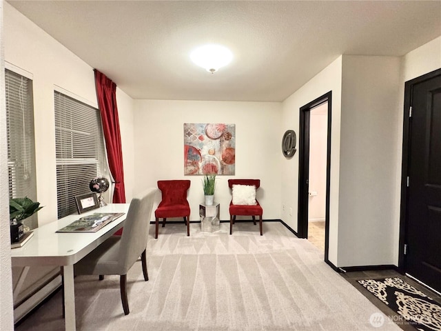 carpeted home office featuring a baseboard heating unit