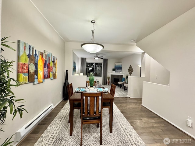 dining space featuring baseboard heating and dark hardwood / wood-style flooring