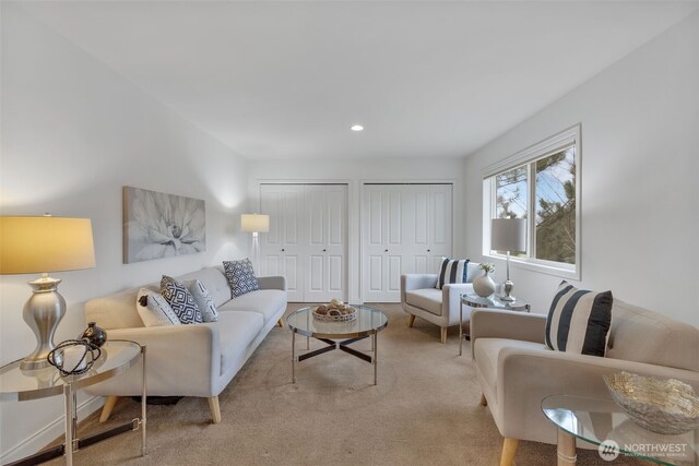 living area featuring light carpet and recessed lighting