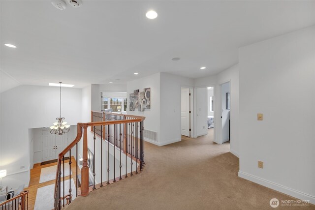 corridor with a notable chandelier, recessed lighting, vaulted ceiling, an upstairs landing, and baseboards