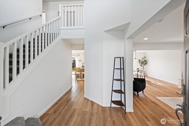 entryway featuring light hardwood / wood-style floors and a towering ceiling