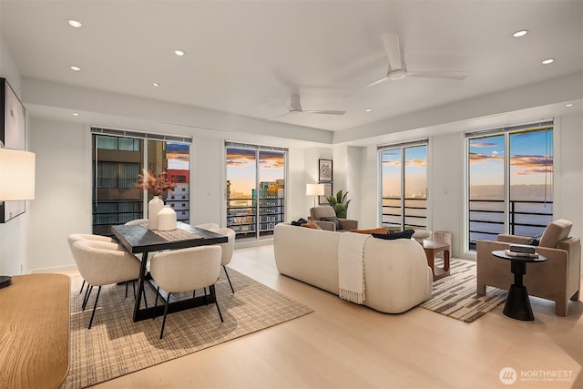 living area with a healthy amount of sunlight, ceiling fan, light wood-style flooring, and recessed lighting