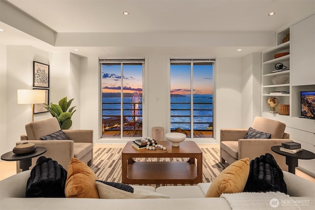 living room featuring built in shelves, wood finished floors, and recessed lighting