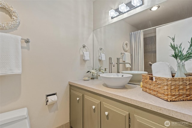 bathroom with vanity, toilet, and walk in shower